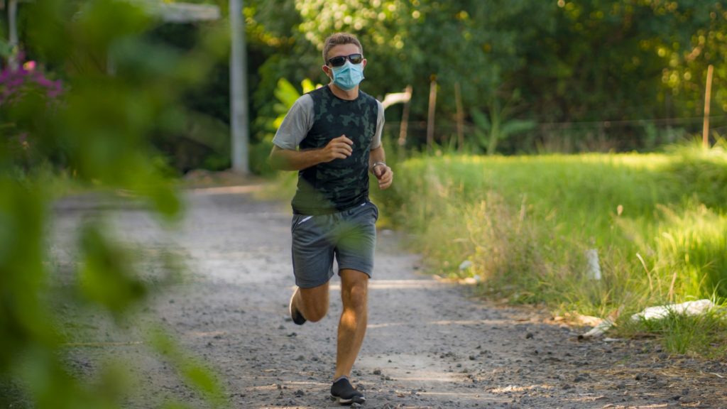 man running with a face mask