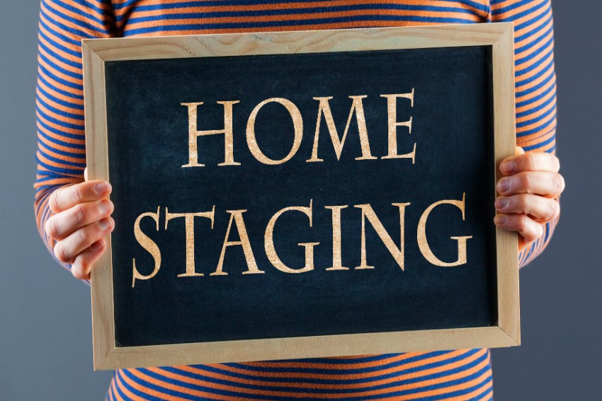 women holding a small blackboard with home staging word